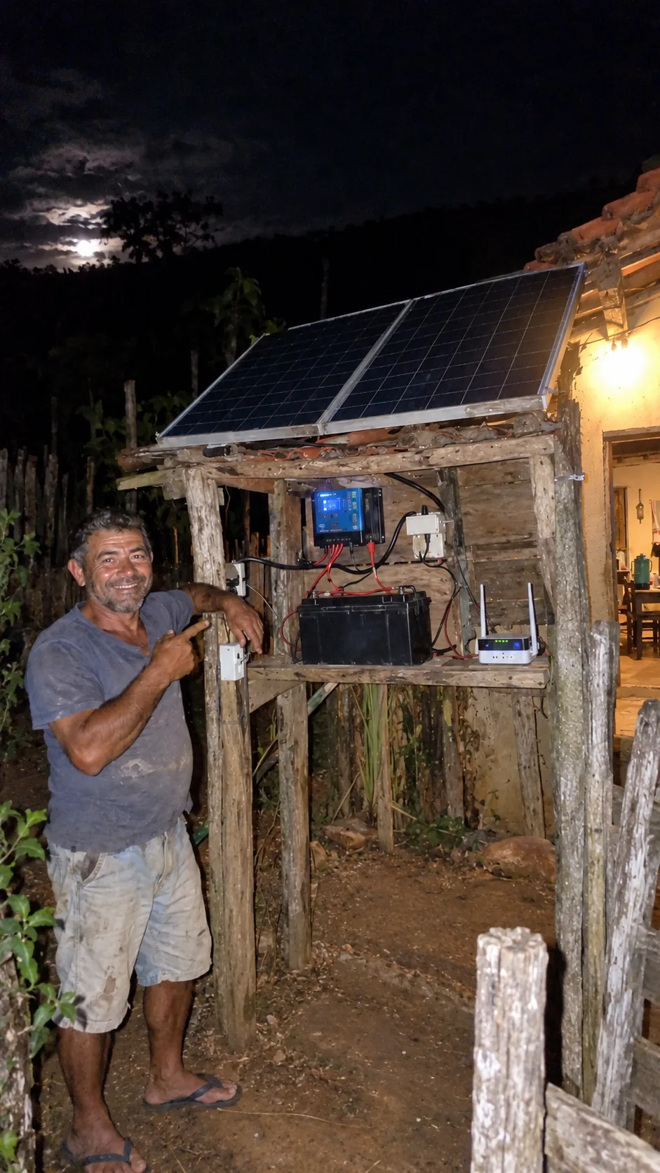 Carlos junto a um sistema de energia solar no sítio à noite